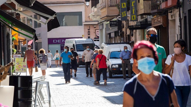 Varias personas protegidas con mascarilla caminan este lunes por la calle más comercial de Aranda. La zona básica de salud de Aranda de Duero (Burgos) presenta este lunes 49 casos de Covid-19. EFE/ Pacosantamaria