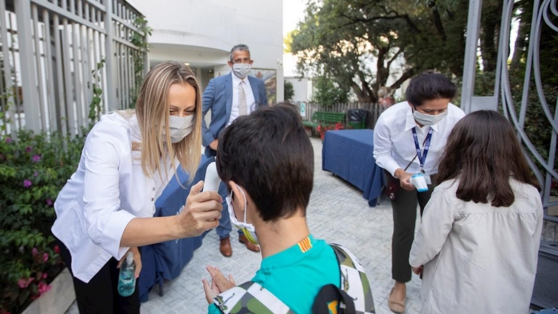 Una trabajadora toma la temperatura a un niño a la entrada del colegio privado internacional American School of Barcelona, en Esplugues de Llobregat (Barcelona). EFE/ Marta Perez/Archivo