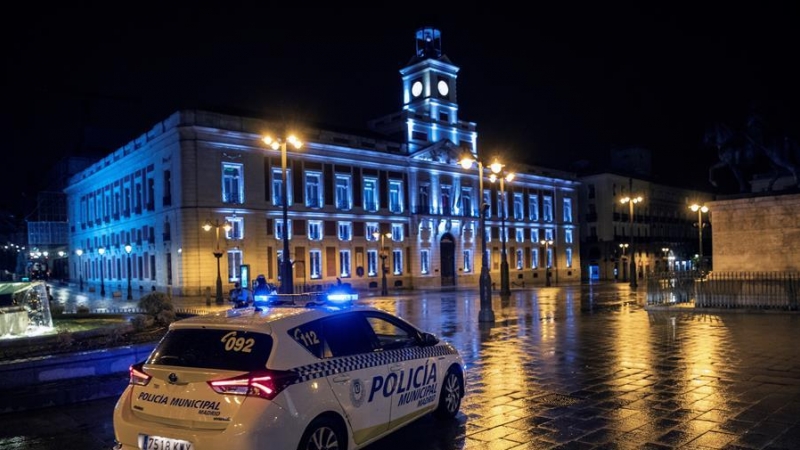 Un coche de la Policía Local vigila la Puerta del Sol anoche, primera jornada de toque de queda en la capital.
