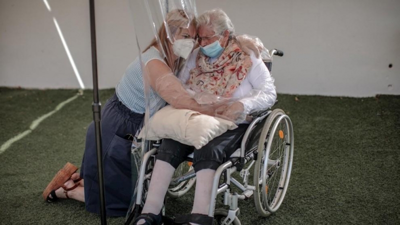 Una interna en una residencia en València abraza a su hija a través de un plástico habilitado para que los familiares se puedan dar su primer abrazo tras los meses de confinamiento.