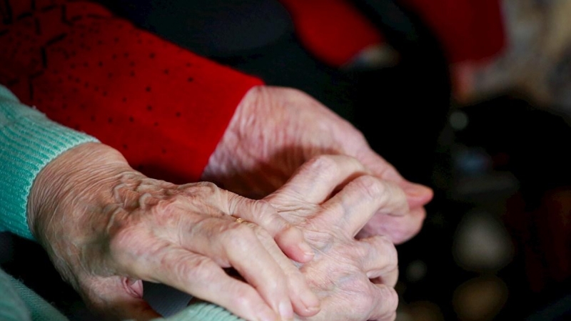 03/12/2020. Imagen de archivo de dos personas mayores cogidas de la mano. - EFE