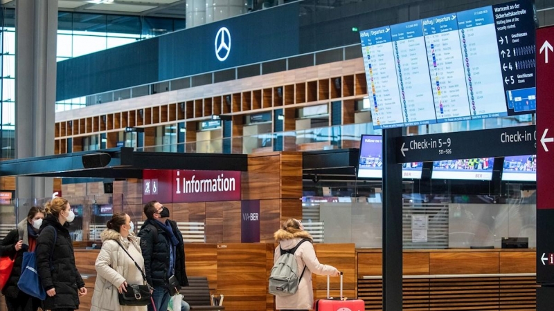 Pasajeros observan el panel de vuelos en el aeropuerto de Berlín. Alemania ha suspendido los vuelos a Reino Unido por la nueva cepa del coronavirus.