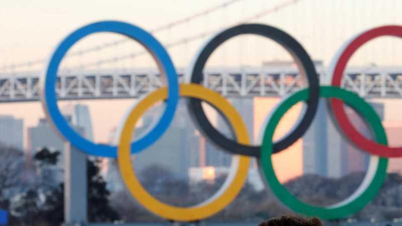 Un hombre frente a una estructura del logotipo de los Juegos Olímpicos en Tokio, Japón
