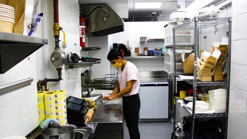 Una socia de una 'cocina fantasma' prepara una comida en su lugar de trabajo.
