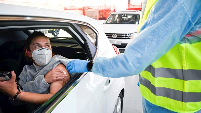 Varias personas reciben una vacuna desde el interior de sus vehículos durante la campaña masiva de vacunación del personal docente de infantil, primaria y secundaria de Granada.