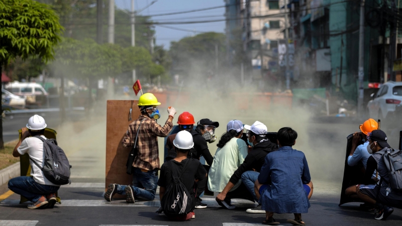 27/02/2021. Los manifestantes se ponen a cubierto mientras los antidisturbios disparan un bote de gas lacrimógeno durante una manifestación contra el golpe militar, en Rangún. - Reuters