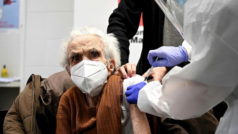 Una sanitaria administra una vacuna a una mujer mayor en el Centro de Salud Barrio del Pilar.
