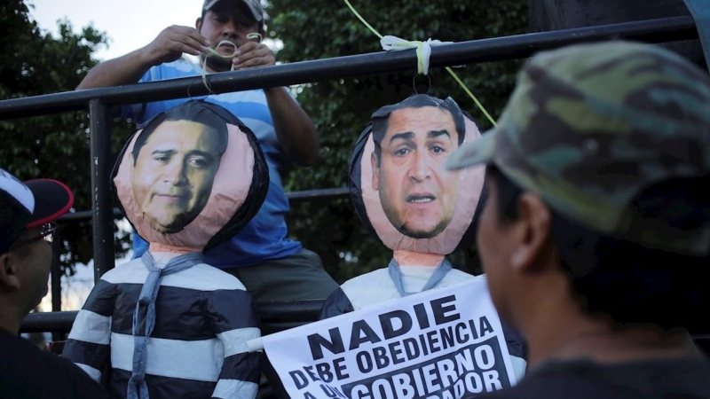 Fotografía de archivo fechada el 25 de octubre 2019 que muestra a manifestantes mientras cuelgan representaciones del presidente hondureño Juan Orlando Hernández (d) y su hermano Juan Antonio 'Tony' Hernández (i) durante una protesta en Tegucigalpa (Hondu