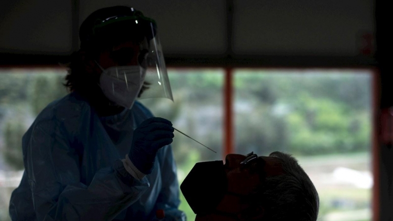 Una trabajadora sanitaria realiza una prueba PCR a un hombre, durante el cribado realizado este lunes a la población de Sobradelo (Carballeda de Valdeorras).