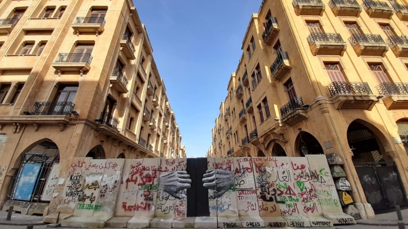 Imagen de un muro en las carres de Beirut en el que se dibujan unas manos que lo abren. - Roula Abdo