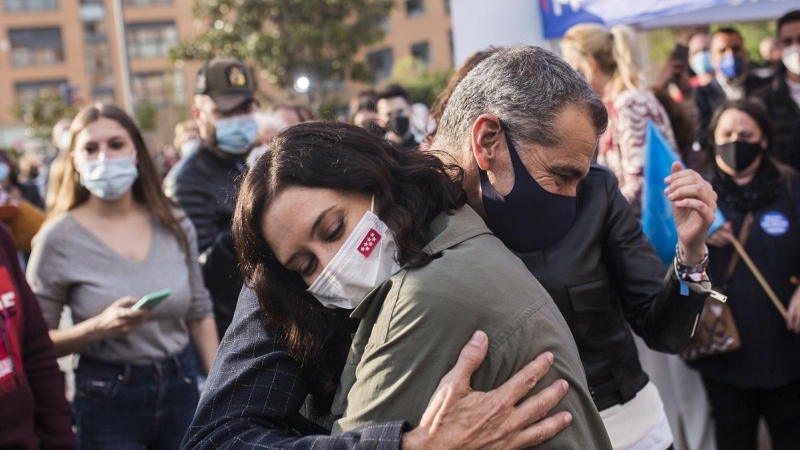 La presidenta de la Comunidad de Madrid y candidata a la reelección, Isabel Díaz Ayuso, abraza a Toni Cantó, durante una visita a la carpa del Partido Popular en San Sebastián de los Reyes, a 14 de abril de 2021.