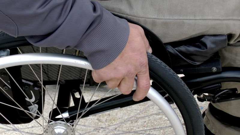 Imagen recurso de una mano accionando una silla de ruedas. - Pixabay