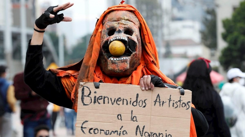 Una persona disfrazada porta un cartel contra la llamada 'Economía Naranja' durante la jornada de manifestaciones denominada Paro Nacional, convocada en todo el país para rechazar, entre otros, la reforma tributaria del Gobierno hoy, en Bogotá (Colombia).
