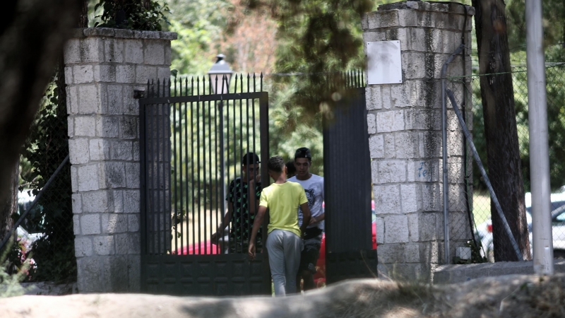 Un joven pasa por la puerta del centro de primera acogida de menores extranjeros no acompañados (menas) situado en la zona de Casa de Campo, en Madrid (España).