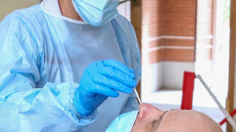 Una sanitaria realiza un test de antígenos a un hombre en un dispositivo organizado por la Comunidad de Madrid para la detección de la covid-19.