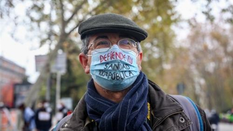 Un hombre lleva una mascarilla donde se lee 'defiende tu sanidad 100% pública' durante una manifestación de la Marea Blanca en Madrid, a 29 de noviembre de 2020.