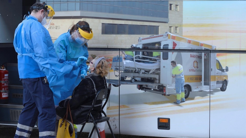 Unos enfermeros realizan un test a una mujer en el exterior de una de las doce unidades móviles que la Junta de Castilla y León ha contratado para hacer test de antígenos a la población que tenga síntomas durante todo el mes de enero, este martes en Vall