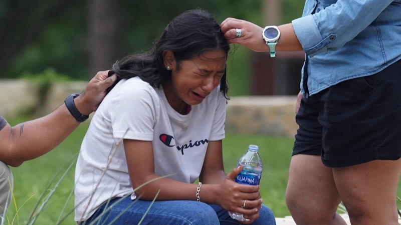 Una niña llora, consolada por dos adultos, afuera del Centro Cívico Willie de Leon, donde se ofrecerá asesoramiento de duelo en Uvalde, Texas, el 24 de mayo de 2022.