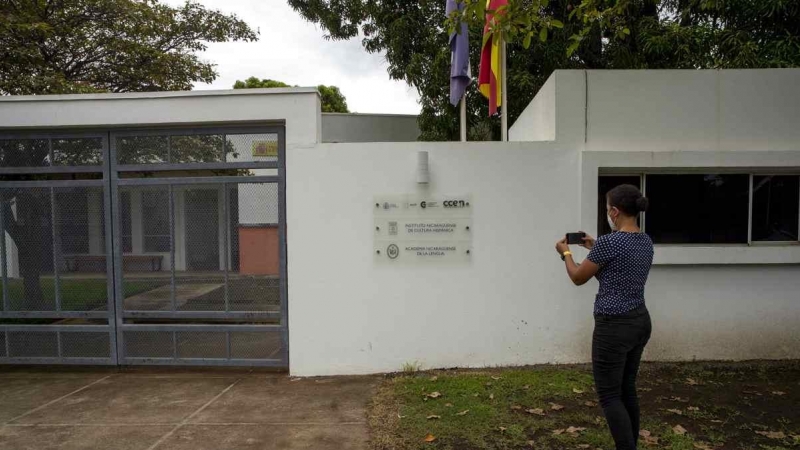 Una mujer toma una fotografía de la fachada de la Academia Nicaragüense de la Lengua(Nicaragua)