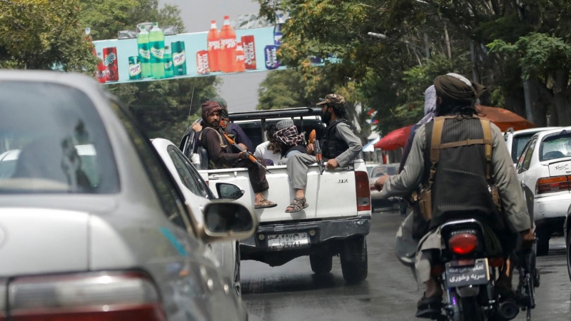 Combatientes talibanes llevan a un hombre detenido en un automóvil militar en Kabul, Afganistán, el 2 de agosto de 2022.