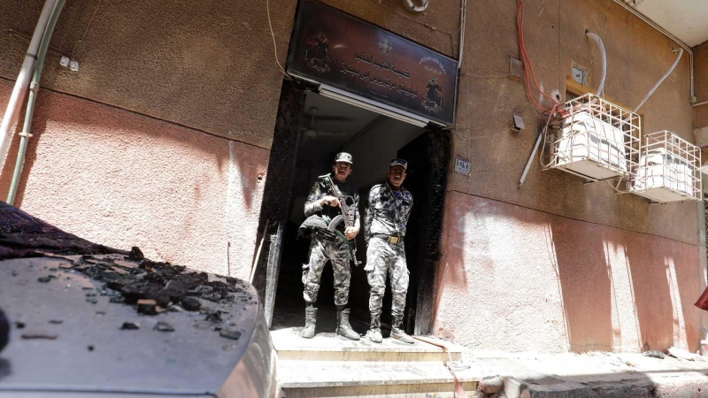 Dos agentes vigilan la entrada de la iglesia de Abu Sefein, donde se produjo el incendio que se cobró la vida de al menos 41 personas.