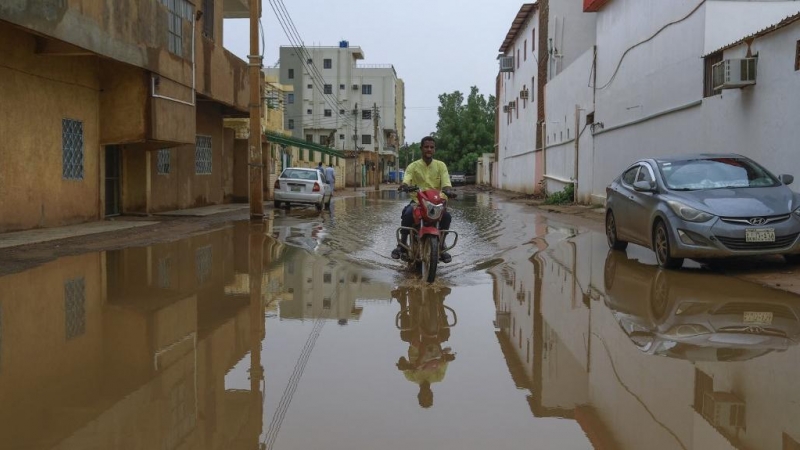 Un hombre tratar de pasar por una calle inundada en Jartum, a 13 de agosto de 2022.