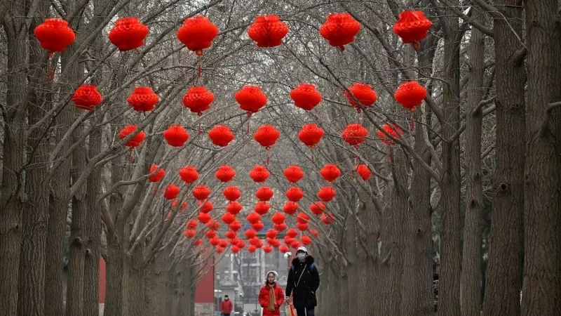 Una niña y su padre caminan por Pekín en la víspera del año nuevo chino.