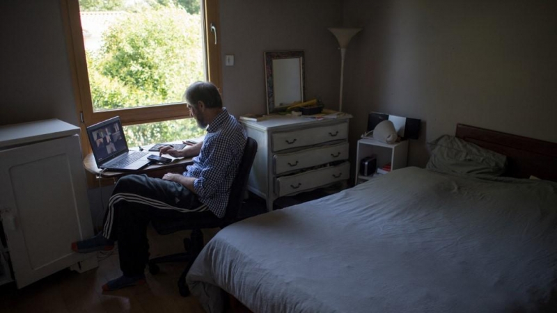 Un hombre teniendo una conferencia online en su habitación.