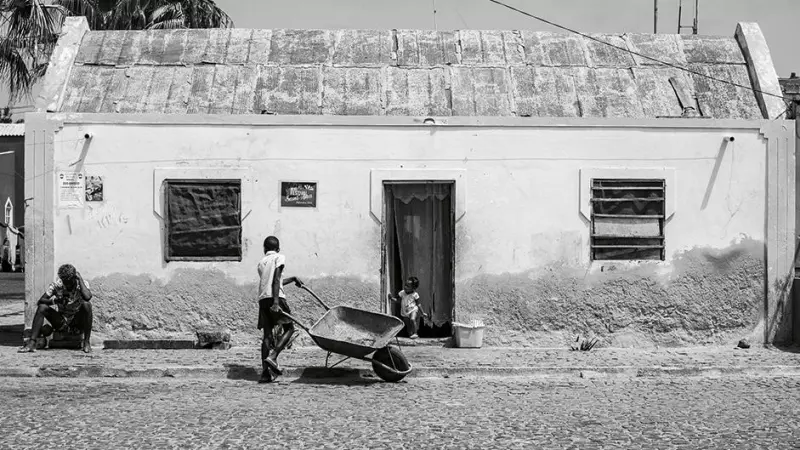 27/3/23 Un niño camina con una carretilla delante de una vivienda en Palmeira | Alba Díaz.