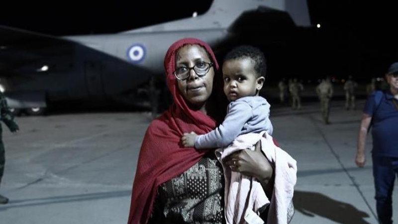 27/4/23 Una refugiada sudanesa con su hijo en el aeropuerto de Attica, en Atenas, el pasado jueves.