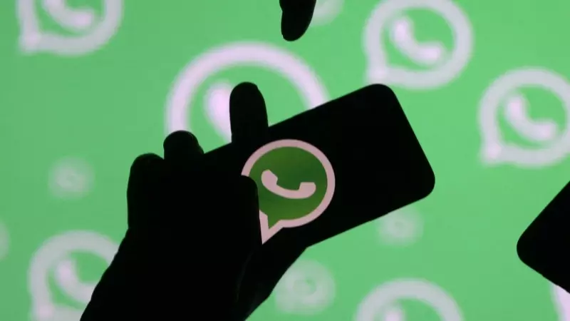Gente posando con teléfonos inteligentes frente al logotipo de WhatsApp, a 14 de septiembre de 2017.
