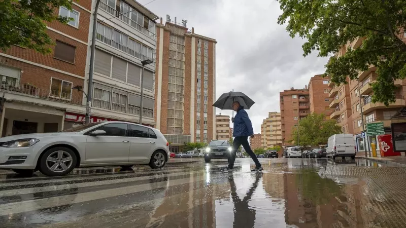 Un hombre se protege de la lluvia bajo un paraguas en Teruel, a 24 de mayo de 2023.