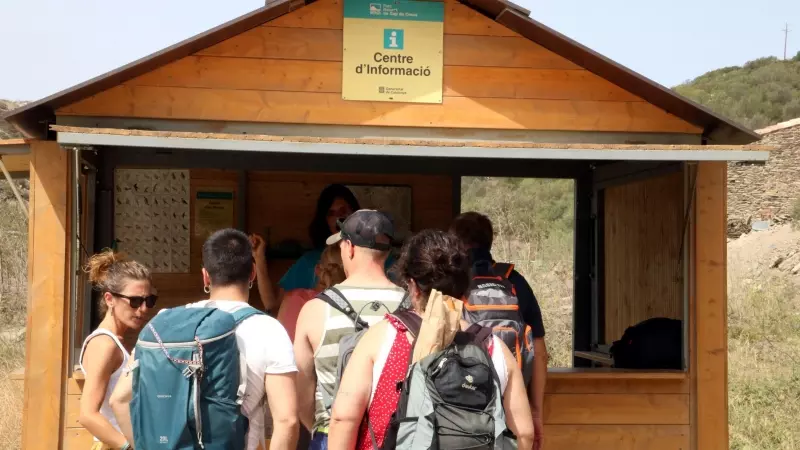 Un grup de turistes al punt d'informació a l'inici de les restriccions del Parc Natural de Cap de Creus a Cadaqués