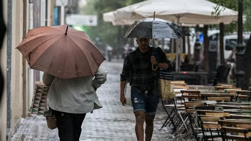 Varias personas se resguardan de la lluvia con paraguas, a 3 de septiembre de 2023, en Madrid