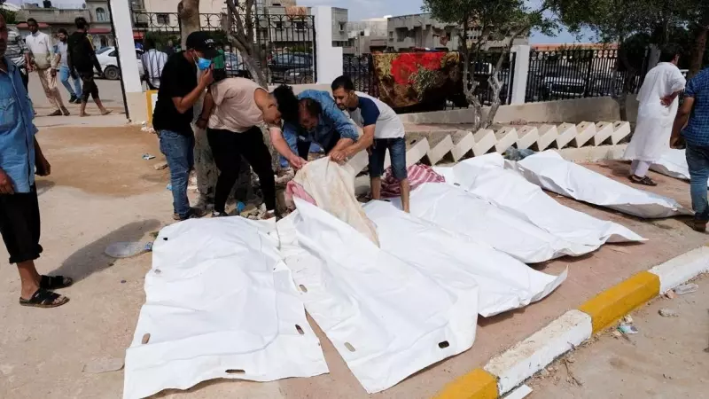 Varias personas buscan entre los cadáveres a familiares y conocidos tras el paso devastador del ciclón Daniel por la ciudad de Derna, en Libia.