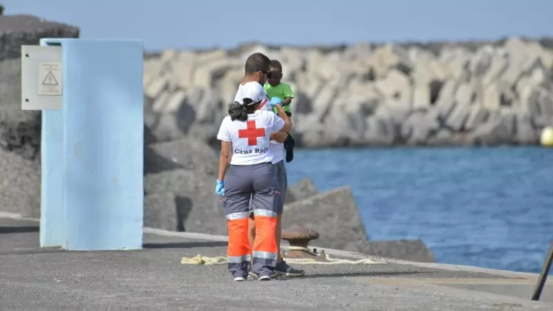 Dos voluntarios de Cruz Roja atienden a uno de los menores llegados al puertos de la Restinga en un cayuco el pasado fin de semana.