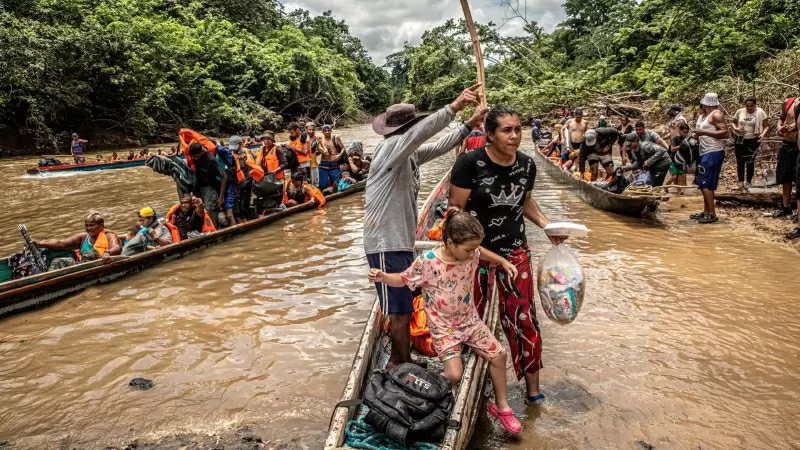 Una migrante venezolana baja junto a su hija de una canoa tras cruzar la selva del Darién, que separa Colombia de Panamá, en su ruta migratoria hacia EEUU.