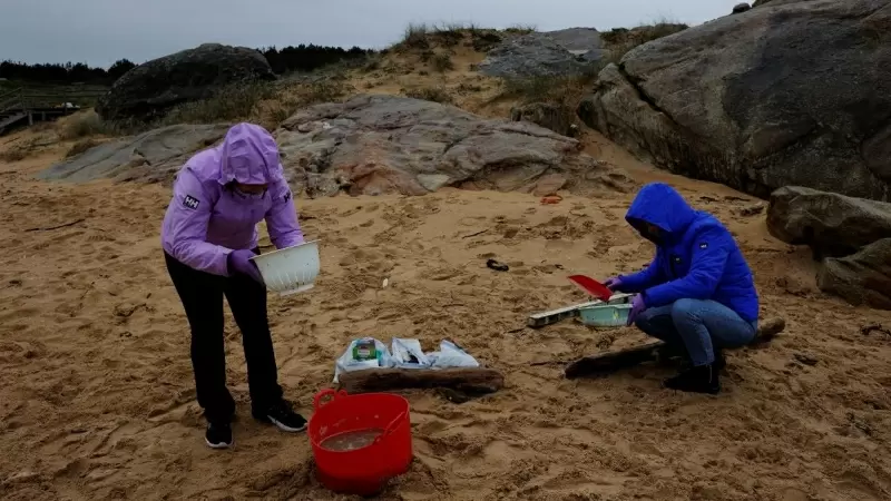 Un grupo de voluntarios trabaja en la limpieza de la playa de Vilar, en A Coruña, contaminada por miles de pellets de plástico.