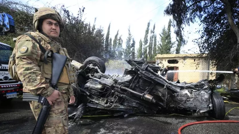 Un bombero apaga un automóvil en llamas atacado por un dron israelí en Al Hoash Road, en el sur del Líbano, el 13 de marzo de 2024.