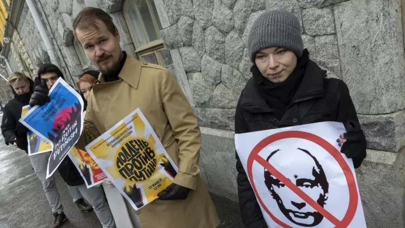 Manifestantes sostienen pancartas con una imagen tachada de Vladimir Putin, mientras los rusos que viven en Finlandia se reúnen para votar en la embajada rusa en Helsinki. 17-03-2024