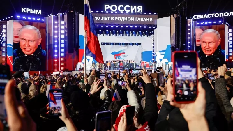 Unas pantallas gigantes muestran el rostro del presidente de Rusia, Vladimir Putin, en un acto en la Plaza Roja de Moscú, para conmemorar el décimo aniversario de la anexión rusa de Crimea de Ucrania, un día después de ser declarado de las recientes elecc