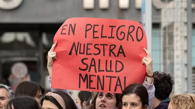 Una joven sujeta una pancarta durante una manifestación