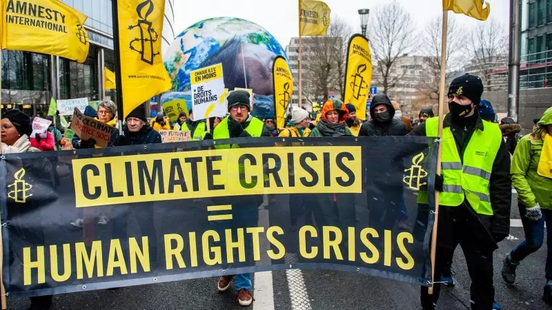 Miembros de Amnistía Internacional protestan en Bruselas por la crisis climática, a 3 de diciembre de 2023.