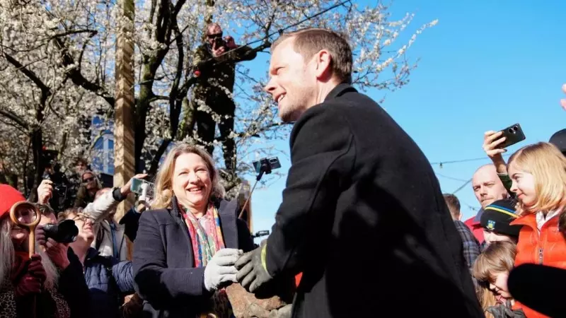El ministro de Justicia danés, Peter Hummelgaard  y la alcaldesa de Copenhague, Sophie Haestorp Andersen sostienen un adoquín mientras los residentes de la ciudad libre de Christiania desentierran Pusher Street