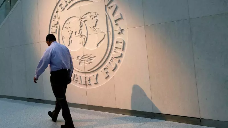 Un hombre pasa caminando por delante del logo del Fondo Monetario Internacional (FMI), en su sede en Washington.