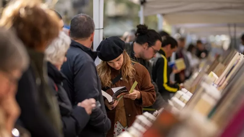 Varias personas miran libros en un puesto durante el día de Sant Jordi 2024, a 23 de abril de 2024, en Barcelona.