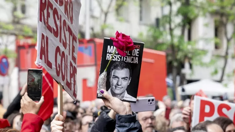 Una persona sujeta un cartel durante una concentración en la calle de Ferraz en apoyo al presidente del Gobierno, Pedro Sánchez, en la sede del PSOE, a 27 de abril de 2024