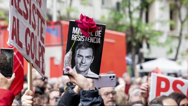 Una persona sujeta un cartel durante una concentración en la calle de Ferraz en apoyo al presidente del Gobierno, Pedro Sánchez, en la sede del PSOE, a 27 de abril de 2024