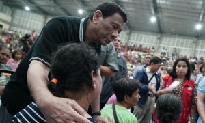El presidente de Filipinas, Rodrigo Duterte, abraza a una mujer evacuada por un tifón en Filipinas. (EFE)