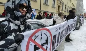 Manifestantes sostienen una pancarta con una imagen tachada de Vladimir Putin en Helsinki, Finlandia, el 17 de marzo de 2024.